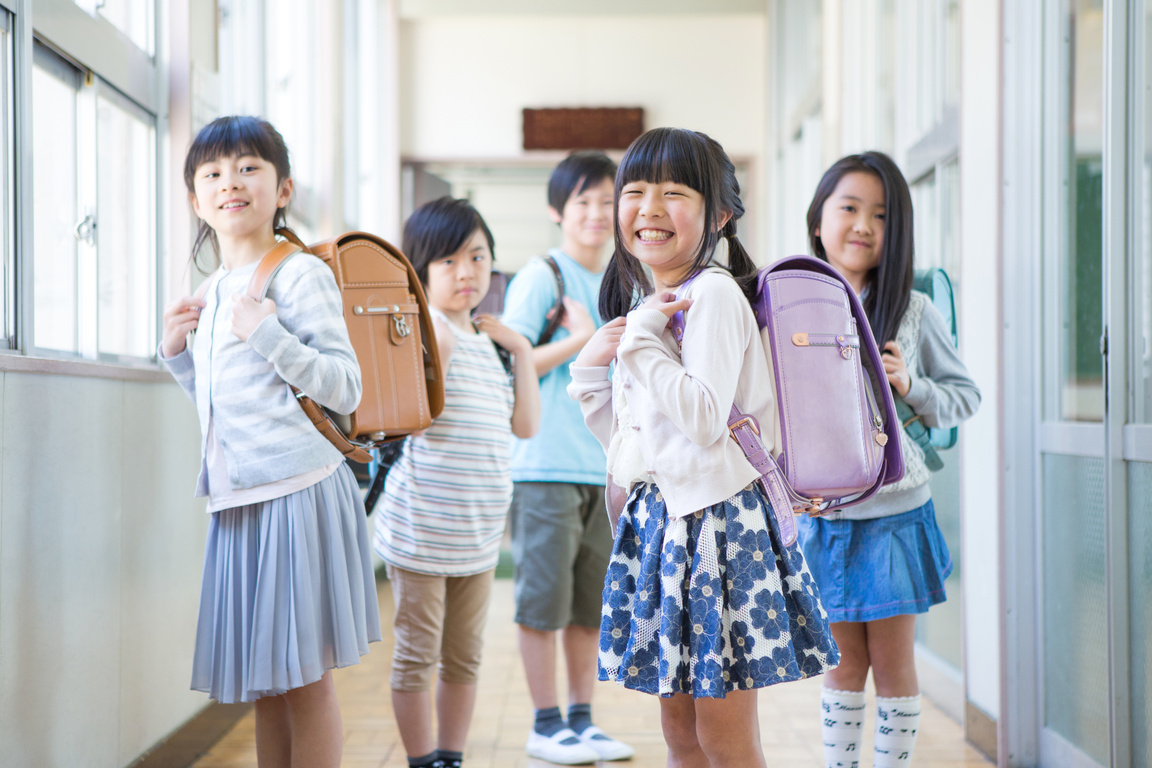 Elementary school children carrying bag